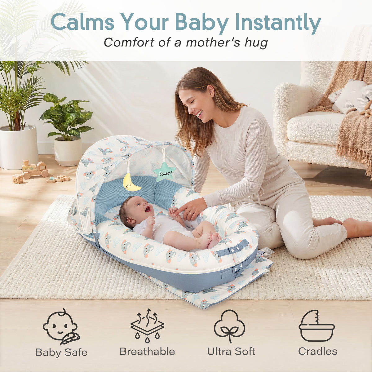 Mother soothing newborn baby in JollyBoo blue elephant infant lounger with canopy, breathable ultra soft baby nest pillow