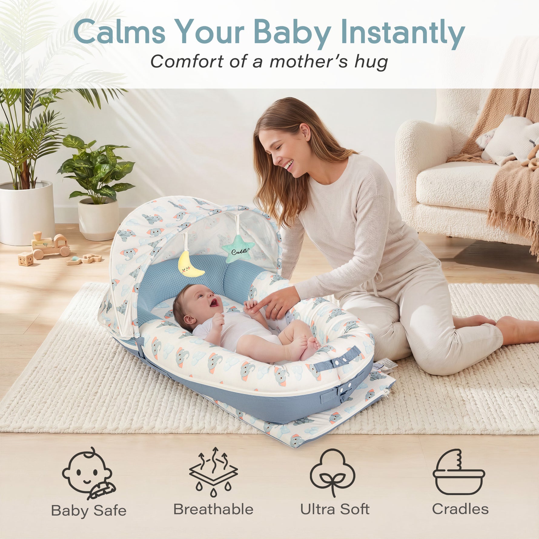 Mother soothing newborn baby in JollyBoo blue elephant infant lounger with canopy, breathable ultra soft baby nest pillow