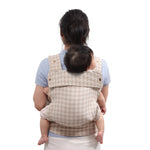 mother holding the baby in her back with a newborn baby carrier