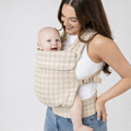 Woman holding her baby in a newborn carrier