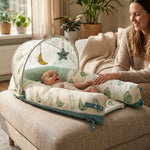 Mother beside awake baby in JollyBoo infant lounger with sunshade and moon and star toys, Sage Leaves print