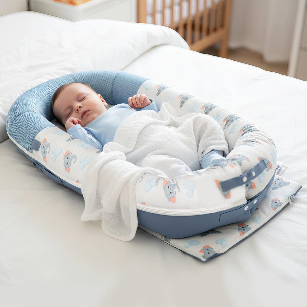 Newborn baby lounging in JollyBoo blue elephant baby lounger, infant nest pillow for supervised lounging