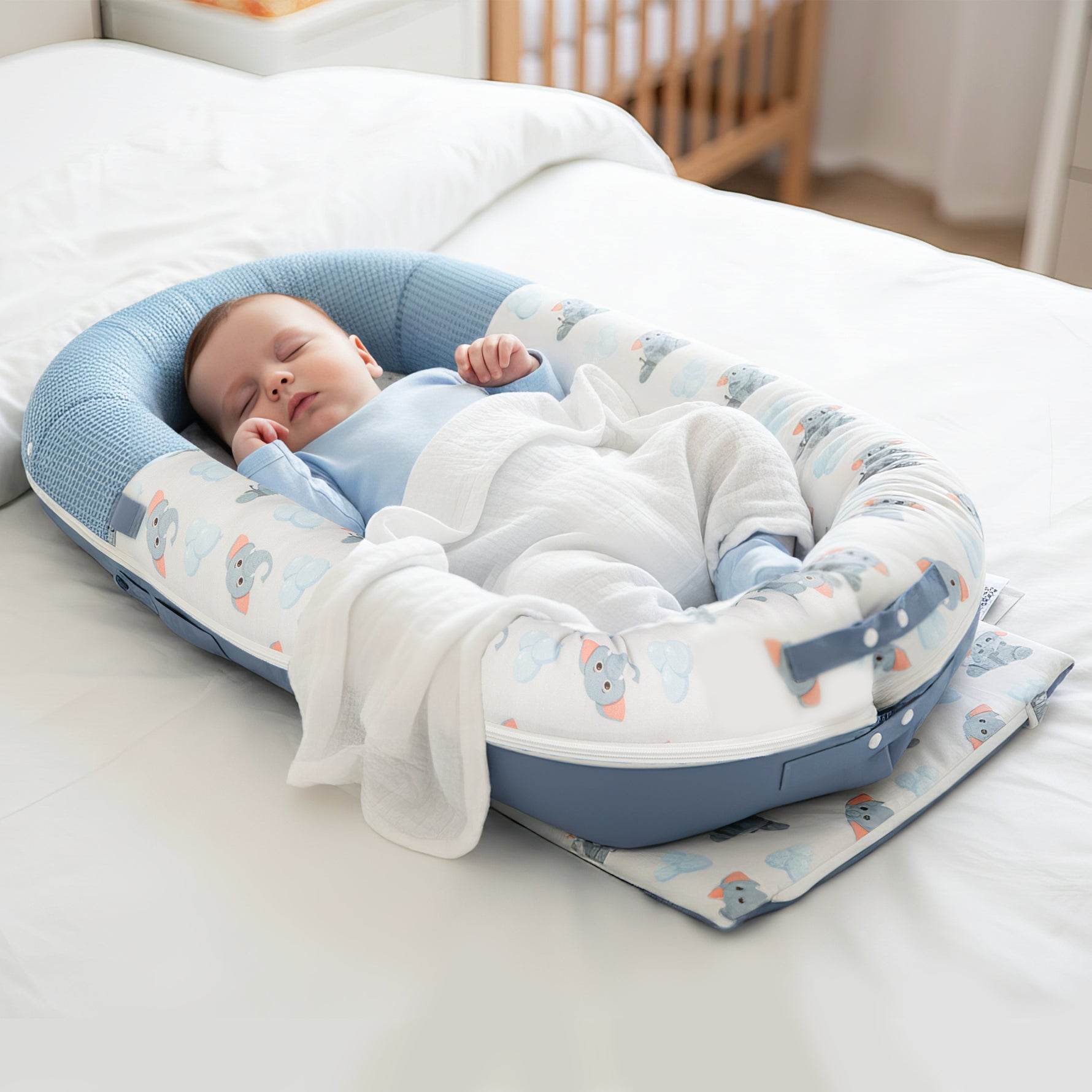 Newborn baby lounging in JollyBoo blue elephant baby lounger, infant nest pillow for supervised lounging